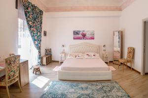 Schlafzimmer mit einem Bett, einem Schreibtisch und Stühlen in der Unterkunft ROSE HOUSE in Syrakus
