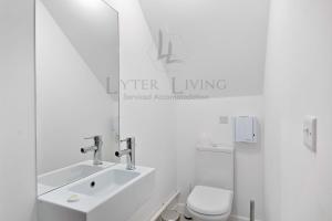 a white bathroom with a sink and a toilet at The Wharf - Oxford City Centre with Garden at Lyter Living Serviced Accommodation Oxford in Oxford