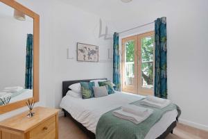 Schlafzimmer mit einem Bett und einem Fenster in der Unterkunft The Wharf - Oxford City Centre with Garden at Lyter Living Serviced Accommodation Oxford in Oxford