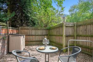 a table and chairs in a backyard with a fence at The Wharf - Oxford City Centre with Garden at Lyter Living Serviced Accommodation Oxford in Oxford