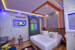 a hotel room with a bed and a tv at Hotel Dar Annasr in Chefchaouen
