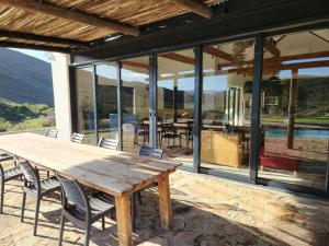 an outdoor dining area with a wooden table and chairs at Ludicks Farm in Montagu