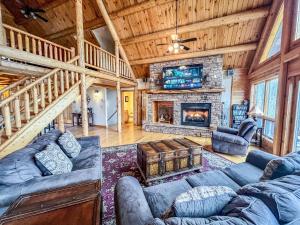 a living room with couches and a fireplace at Lake Access Dock Hot Tub Fire Pit Game Room More in Swanton