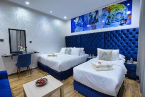 una camera d'albergo con due letti e un tavolo di Hotel Dar Annasr a Chefchaouen