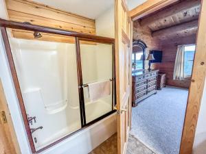 Baño con puerta corredera de cristal en una cabaña de madera en Lake Access Dock Hot Tub Fire Pit Game Room More, en Swanton