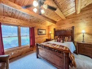 a bedroom with a bed in a log cabin at Lake Access Dock Hot Tub Fire Pit Game Room More in Swanton