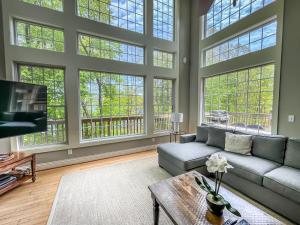 a large living room with large windows and a couch at Amazing Central Location Lakefront Hot tubdock in Oakland