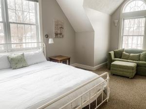 a bedroom with a large white bed and a chair at Amazing Central Location Lakefront Hot tubdock in Oakland