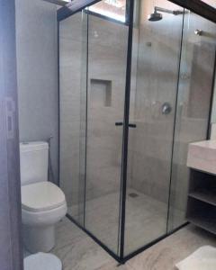 a bathroom with a toilet and a glass shower at Villas BobZ Apt.109 in Barra Grande