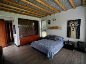 a bedroom with a large bed and a wooden floor at La Colina in Tabio