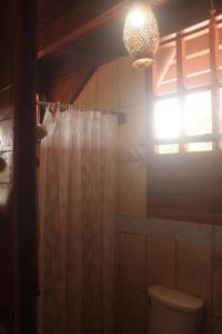 a bathroom with a shower curtain and a toilet at Madera Labrada Lodge Ecologico in Tarapoto