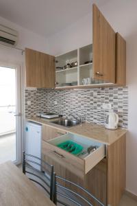 a kitchen with a sink and a counter top at Socrates Apartmens & Restaurant in Milatos