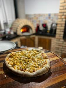 eine Pizza auf einem Holztisch in der Unterkunft Cantin da Mata in Domingos Martins