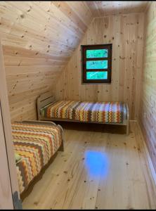 a room with two beds and a window in a log cabin at VESNA HOUSE in Kolašin