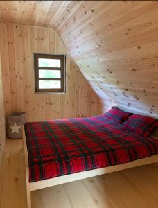 a bedroom with a bed in a wooden cabin at VESNA HOUSE in Kolašin
