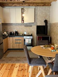a kitchen with a wooden table and a dining room at VESNA HOUSE in Kolašin