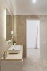 a bathroom with a white sink and a mirror at Three Seasons in Kavos