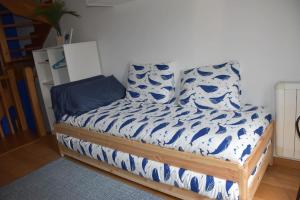 uma cama com lençóis e almofadas azuis e brancos em Casa Punta Balea, en el centro em Cangas