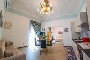 a kitchen and living room with a chandelier at ROSE HOUSE in Siracusa