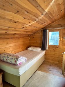 a bed in a wooden room in a cabin at Ayder Bulut Dağevi Bungalow in Ayder Yaylasi