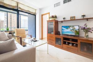 een woonkamer met een bank en een tv bij Gemelos 23 Apartment 5-A Levante Beach in Benidorm