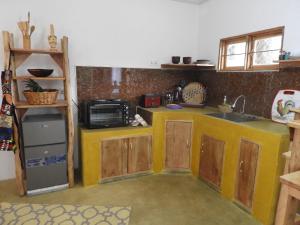 cocina con fregadero y microondas en Holiday cottage by the river, Arusha, en Arusha