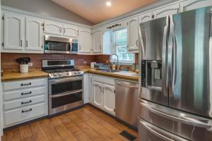 eine Küche mit weißen Schränken und einem Kühlschrank aus Edelstahl in der Unterkunft Charming Temple Home Sunroom and Private Backyard! 