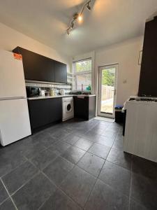uma cozinha com um frigorífico branco e piso em azulejo em Bright & Central Home em Church Coppenhall