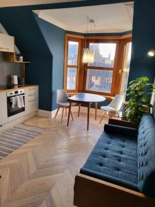 ピーターヘッドにあるTrinity apartments n56の青い壁のリビングルーム(テーブル付)