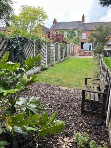a garden with a fence and a bench in a yard at Bright & Central Home in Church Coppenhall