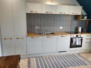 a kitchen with white cabinets and a sink at Trinity apartments n56 in Peterhead