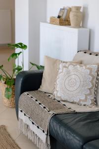 un sofá de cuero negro con una almohada en él en La Hacienda, en Pigi