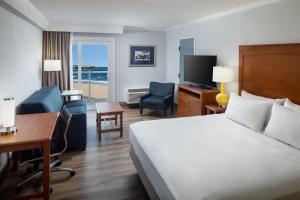 a hotel room with a bed and a desk and a room at Ashworth by the Sea in Hampton