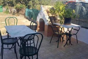 un patio con 2 mesas y sillas y una maceta en Casa Rural Paraiso de Emilia, en La Aulaga