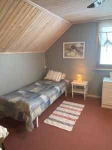 a bedroom with a bed and a table and a window at Flaka hill 15 in Lycksele