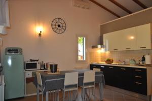 uma cozinha com mesa e cadeiras e um relógio na parede em KAMENJAK VOLME, Cousy house with Pool em Banjole