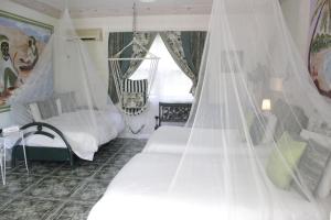 a bedroom with two beds and a mosquito net at The Legend Garden Condos in Saint Peter