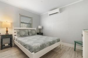 biała sypialnia z łóżkiem i oknem w obiekcie Matlacha on Shoreview w mieście Matlacha