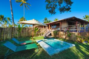 een achtertuin met een zwembad en een huis bij Reserva Jacumã Boutique - Trancoso in Trancoso