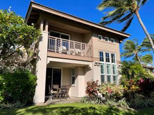 a house with a balcony and a table and chairs at Summer Special! Hilton Pool Pass included! in Waikoloa
