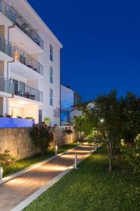 ein Apartmenthaus in der Nacht mit einem Baum davor in der Unterkunft Apartments Villa Ankora in Dubrovnik