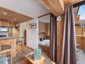 a bedroom with a bed and a desk in a room at Charmant appartement cosy au centre de Val Thorens avec WiFi - FR-1-640-20 in Val Thorens