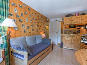 a couch in a living room with a wooden wall at Appartement chaleureux 6 pers skis aux pieds avec parking couvert au coeur de Val-d'Isère - FR-1-694-229 in Val dʼIsère