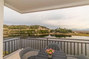 a table and chairs on a balcony with a view of a lake at Lakeview Apartments in Ploče