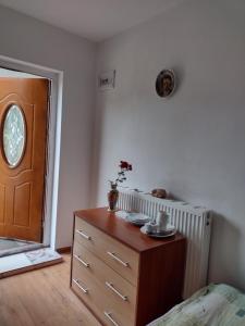 um quarto com uma cómoda e uma porta de madeira em Agroturystyka em Kosarzyn