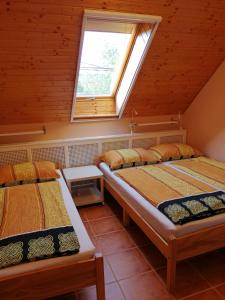 two beds in a room with a window at Karpatia Panzio in Esztergom