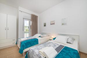1 Schlafzimmer mit 2 Betten und einem Balkon in der Unterkunft Lakeview Apartments in Ploče
