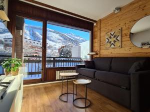 a living room with a couch and a large window at Appartement Les Deux Alpes, 2 pièces, 4 personnes - FR-1-516-200 in Les Deux Alpes