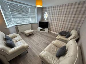 een woonkamer met 2 banken en een tv bij Fresh & Spacious House in Rhyl