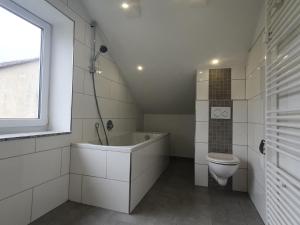 Külsheim的住宿－ruhige und moderne 2-Zi. Wohnung，浴室配有卫生间、浴缸和水槽。